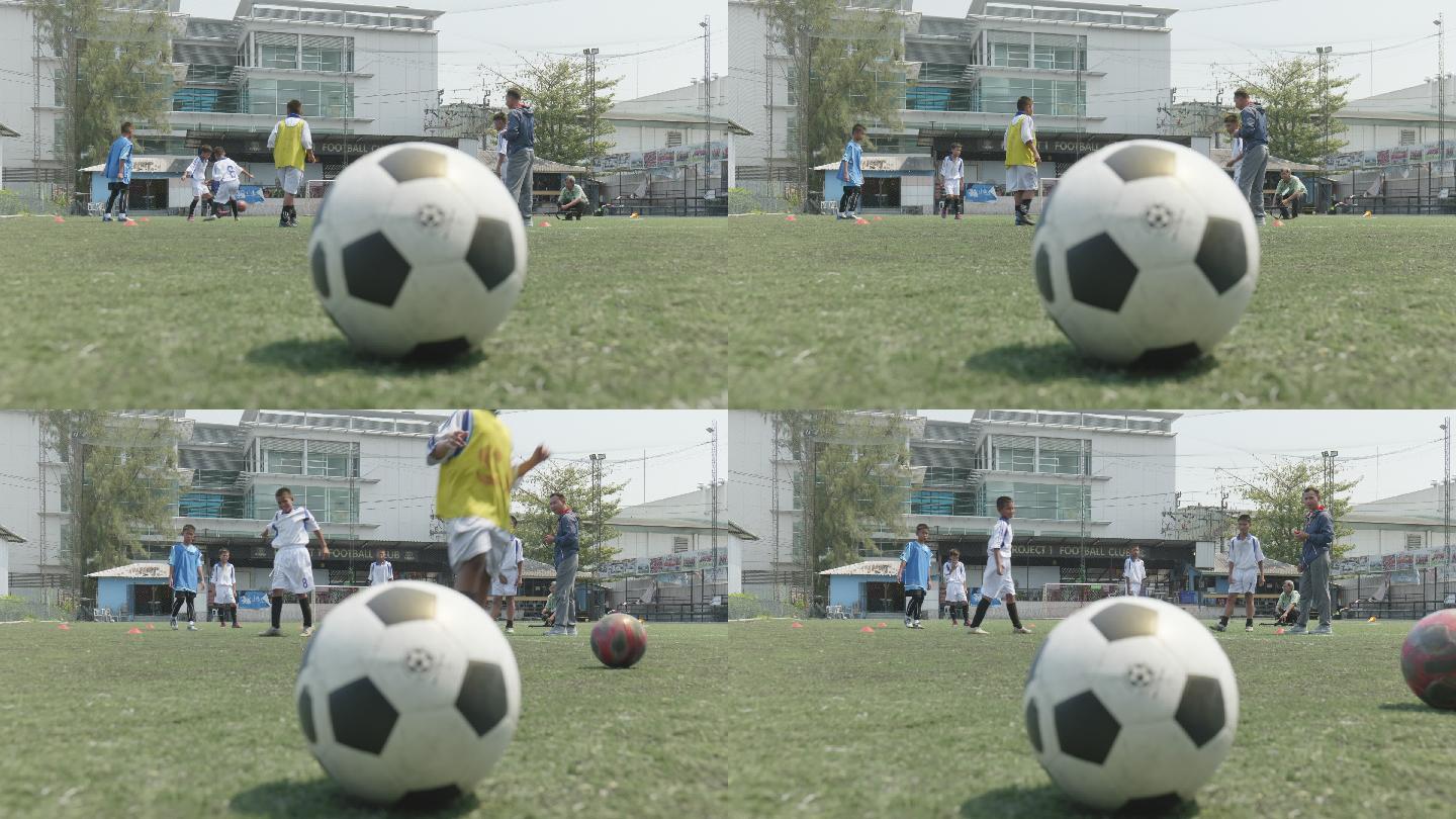 球的特写镜头，背景是一个正在踢足球的孩子。