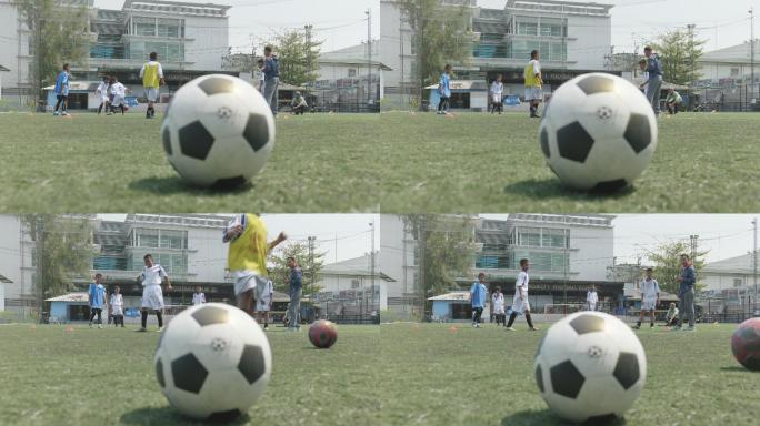 球的特写镜头，背景是一个正在踢足球的孩子。