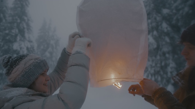 这对夫妇准备在雪地里放纸灯笼