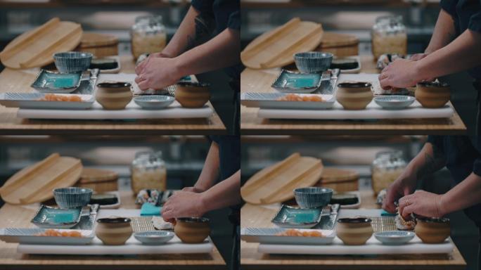 日本厨师在制作寿司卷时将三文鱼放在米饭上的侧视图