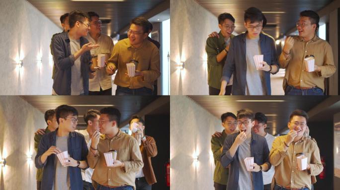 周末，快乐的亚裔中国男性朋友走在走廊上看电影