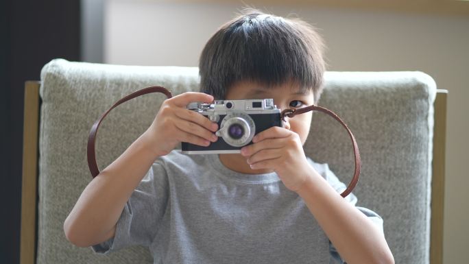 亚洲小孩用老式相机拍照