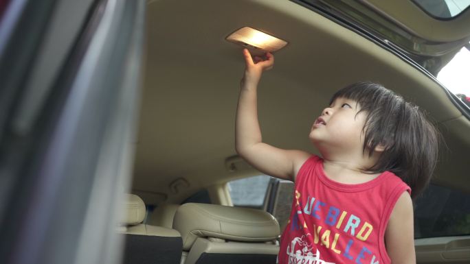 男婴在后备箱的汽车顶灯上“关”和“开”