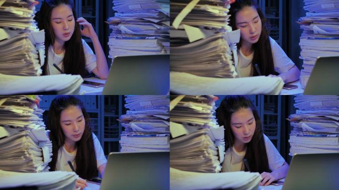 21岁的亚洲年轻女性因工作到深夜而在办公桌上用电脑过度劳累。与技术概念作斗争的人们。