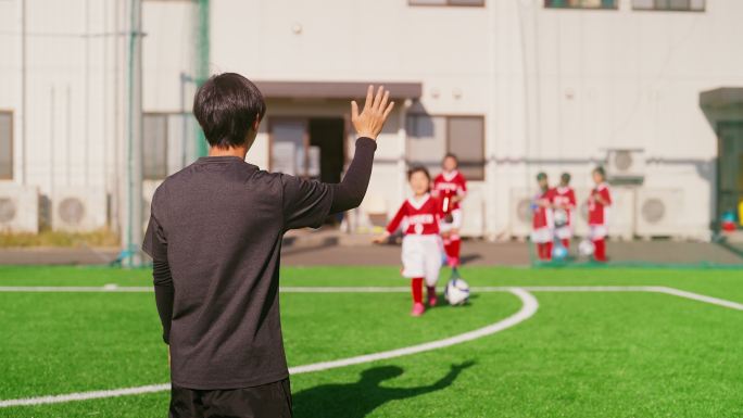 女性儿童足球队或足球队成员在做蜂巢五时问候教练