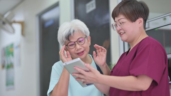 华裔亚裔女护士在诊所向其资深女患者解释体检报告
