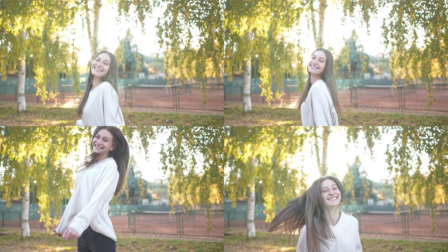 慢镜头中，微笑的美女在公园里跳跃，而太阳正在升起