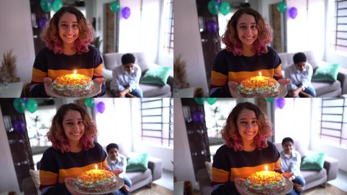一位年轻女子在家里拿着生日蛋糕的肖像