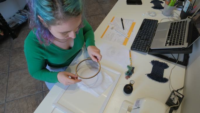 年轻女子正在准备刺绣箍的设计