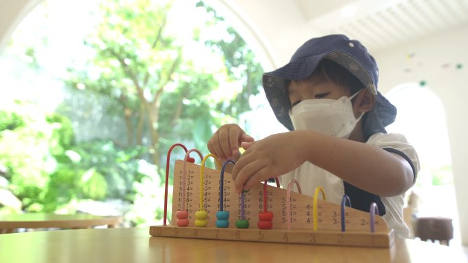 幼儿在游戏室玩算盘学习数学玩具