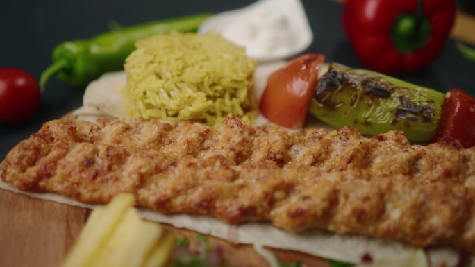 大盘子上的肉丸配米饭和沙拉，装饰后即可食用。土耳其菜烤肉盘