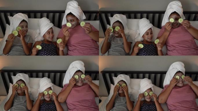 莫瑟和女儿们在床上用黄瓜片敷在眼睛上做皮肤护理