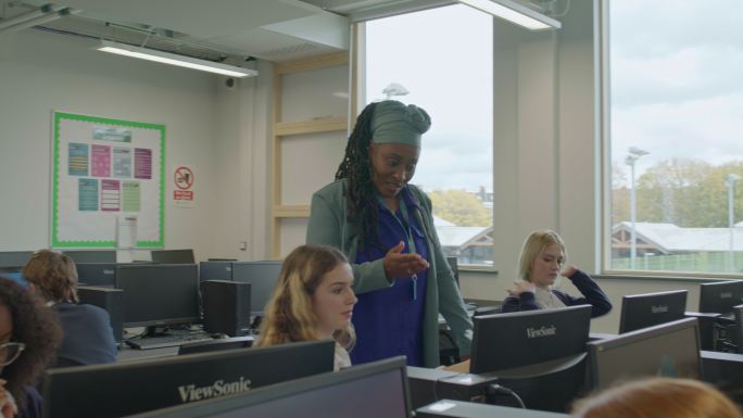 教育家在计算机实验室帮助青少年学生
