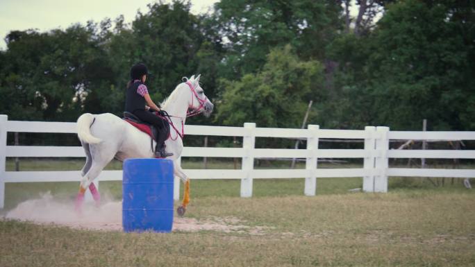 年轻的亚洲女孩喜欢在农场骑马，女孩在牧场骑马训练
