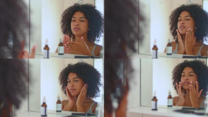 4k视频片段，一名女子在对着浴室镜子时涂面霜