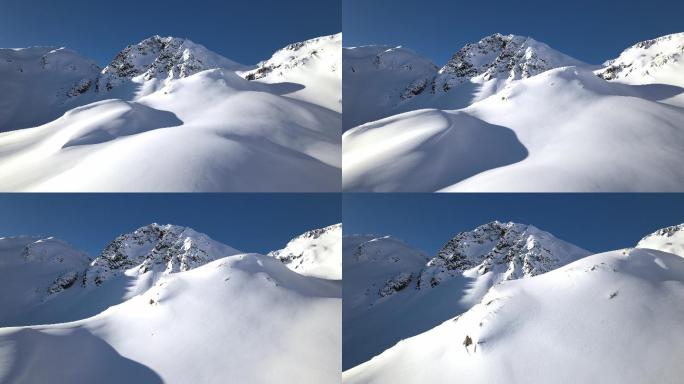 在晴朗的日子里，无人驾驶飞机朝着白雪覆盖的山脉飞去