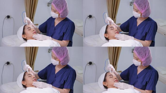 美容美容师在患者前额皮肤上进行皮肤针治疗。亚洲年轻美丽的女性在脸上做微针介观疗法，收紧、提升和恢复皮