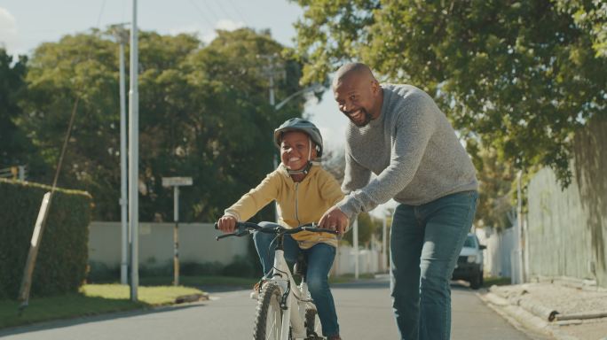 4k视频，一位英俊的成熟男子教儿子如何在户外骑自行车
