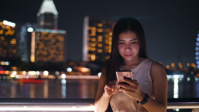 亚洲女性在新加坡夜市使用智能手机