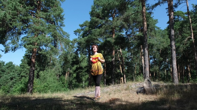 一个成熟的女人在自然公园和阻力带一起锻炼