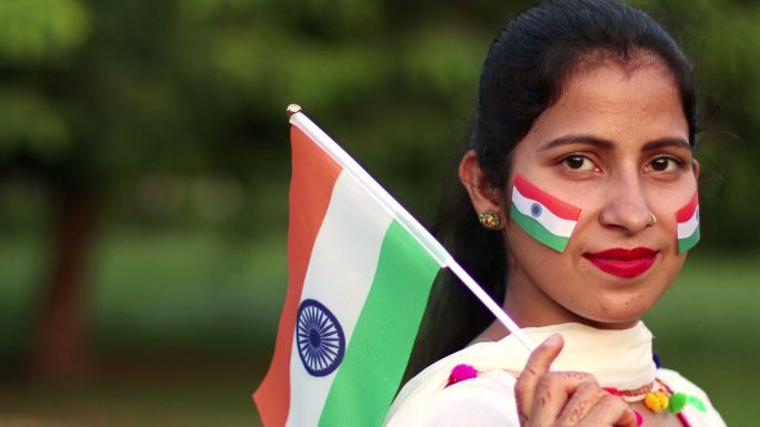 年轻的印度女子举着印度国旗