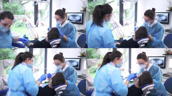 牙医和助理治疗牙科诊所的病人。