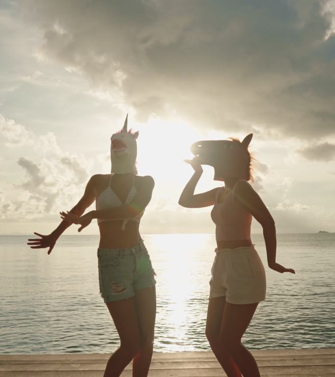 两个女人假扮成马和独角兽在海边跳舞。