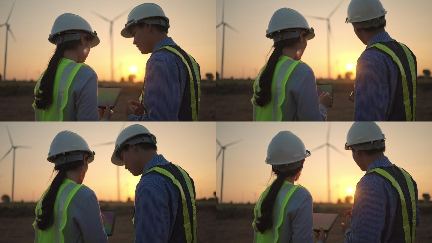 两名工程师在风力发电厂一起工作时使用数字平板电脑