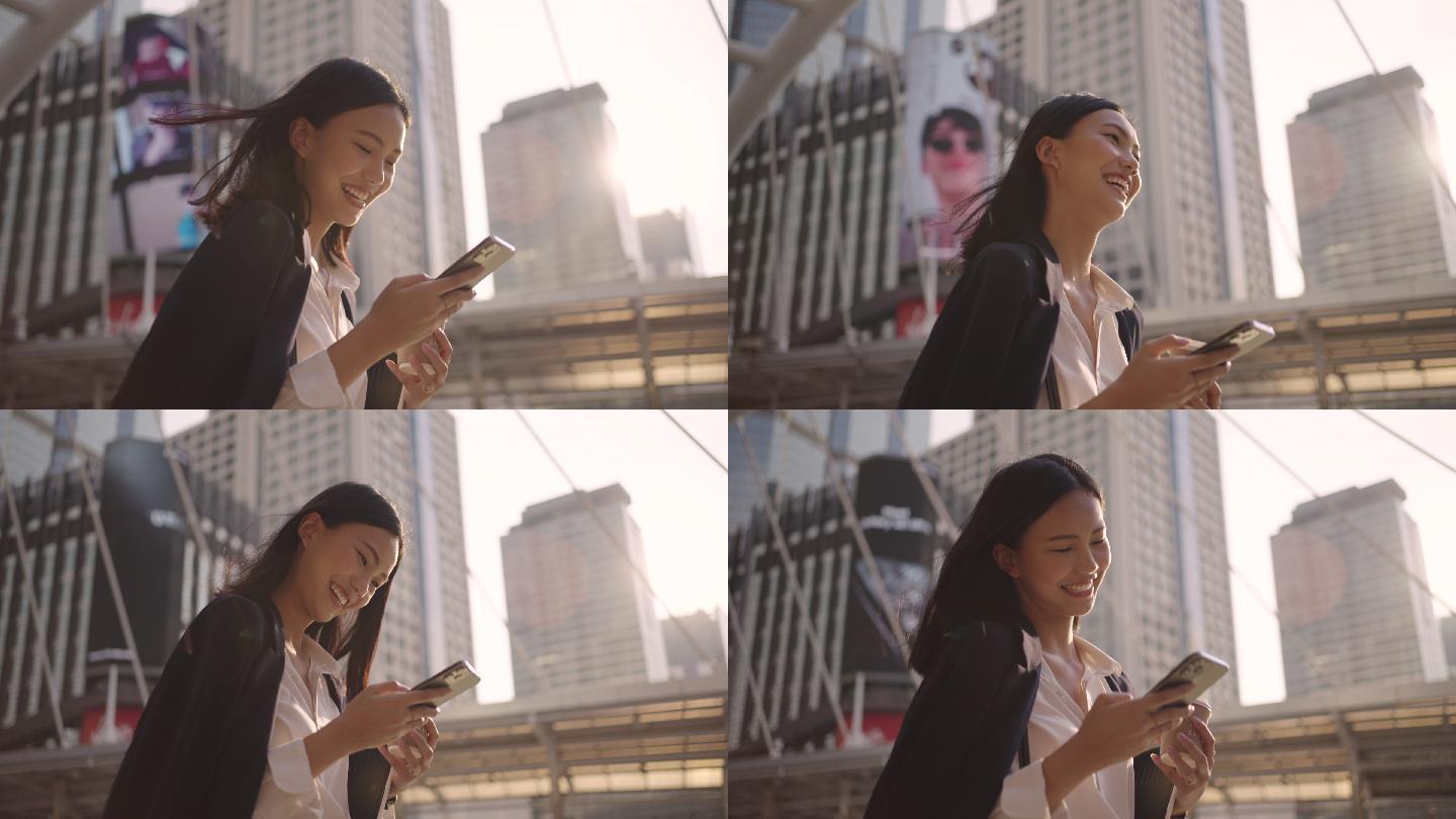 日落时分，女商人一边在城市里用智能手机一边走路