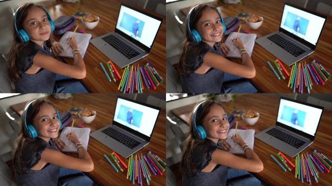 一个女孩在家上学时使用笔记本电脑的照片