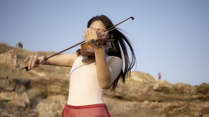 在山上拉小提琴的女人。