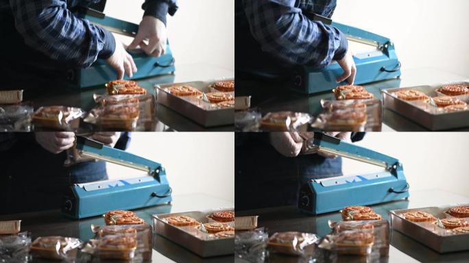 一位亚洲男面包师把自制的中国月饼放进塑料袋里