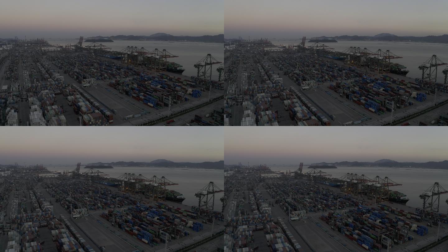 日落后的海港码头上，卡车仍在密集的集装箱之间忙碌穿梭