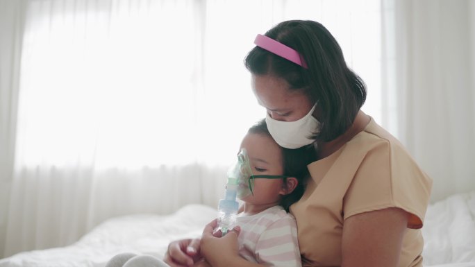 母亲用吸入器、喷雾器治疗照顾女儿