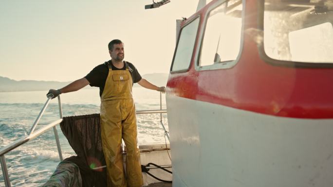 渔民在小型拖网渔船上驾驶的动作肖像