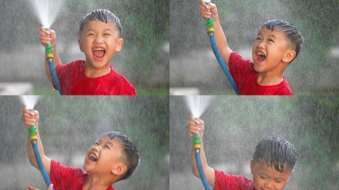穿着靴子的亚洲小孩在公园里玩泼水和泥巴游戏。夏天和幸福的概念