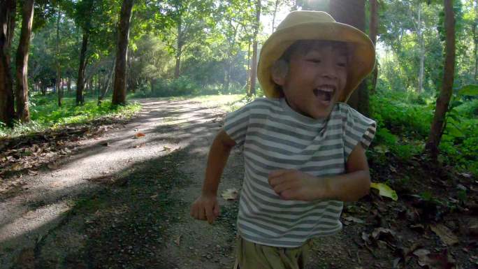 亚洲小孩在热带雨林的路上奔跑。