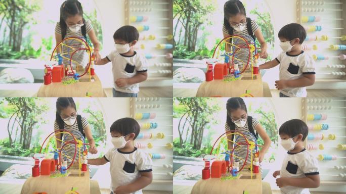 一个蹒跚学步的男孩在游戏室和妈妈玩算盘学习数学玩具