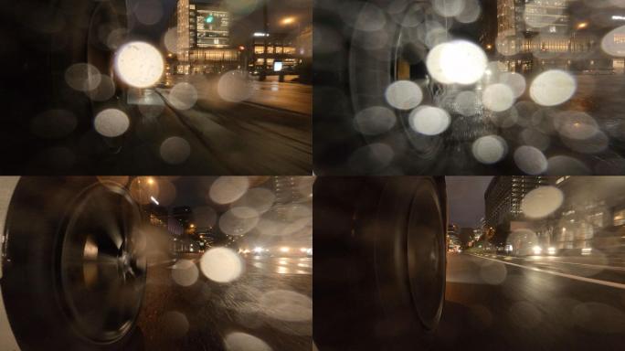 在雨夜开车穿过城市。汽车车轮的特写镜头。在十字路口右转