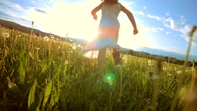 日落时在草地上奔跑的超级懒鬼女孩