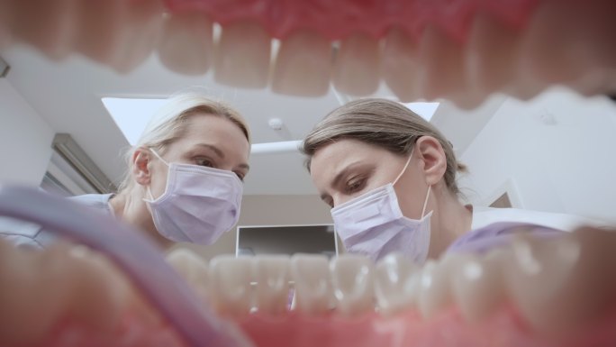 POV助手在牙医开始对牙齿进行治疗前，将吸管放入患者口腔