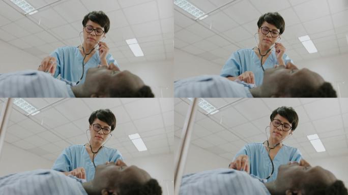 女医生在急诊室用听诊器听心跳。