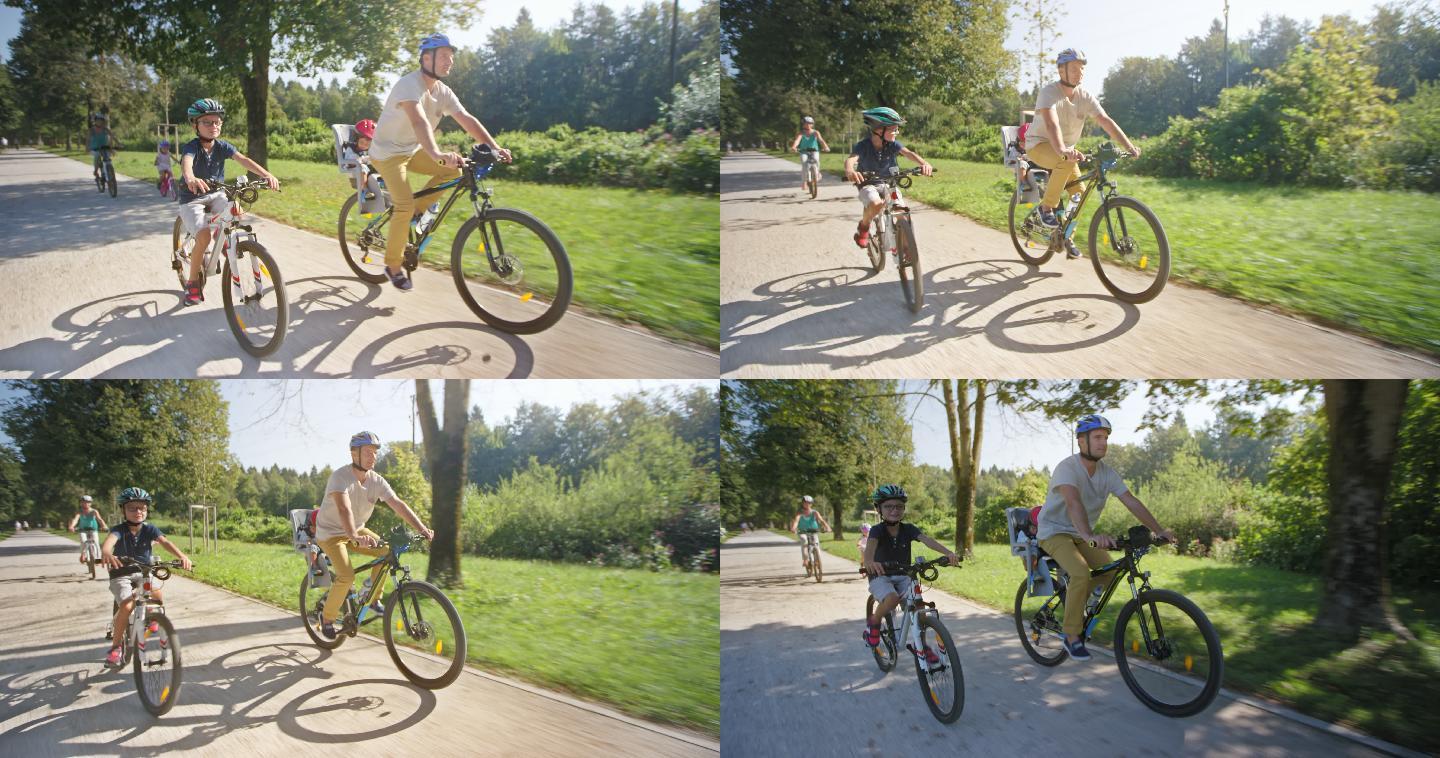 一名男子和他的家人在阳光明媚的公园里骑自行车，他蹒跚学步的儿子坐在自行车后座上