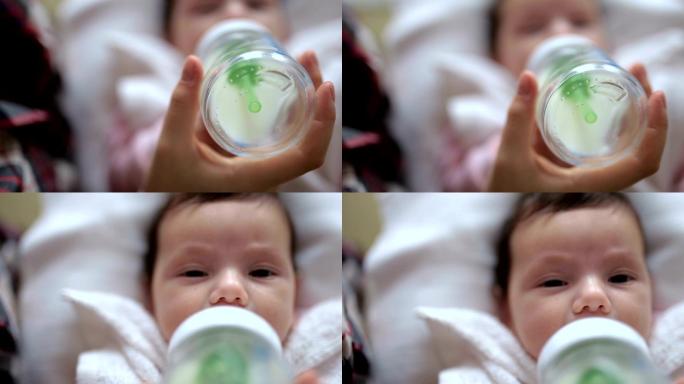 母亲用婴儿奶瓶喂婴儿