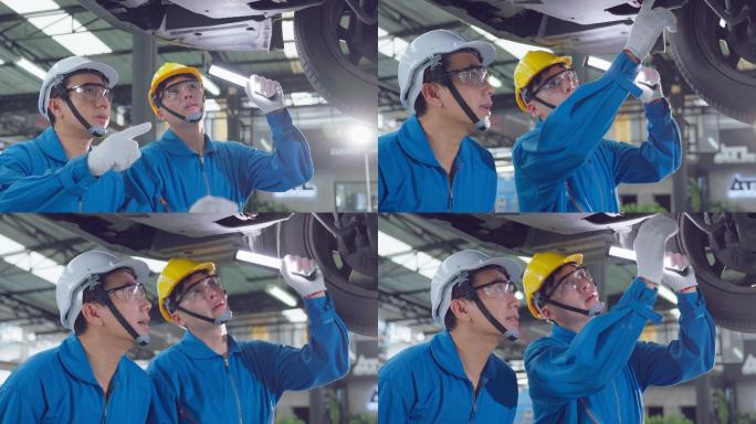 两名亚裔汽车修理工戴着头盔在修理厂工作。车辆服务经理团队男性工人检查车辆状况，检查和维护，以在车间维