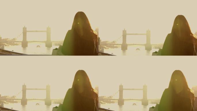 远景：日落时分，塔桥旁一名女子的剪影