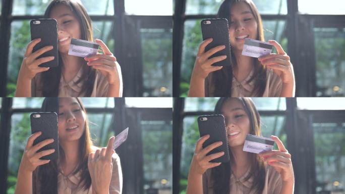 亚洲年轻女子用信用卡在手机上购物