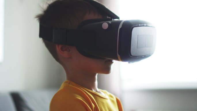 快乐男孩使用VR头戴式虚拟现实模拟器，环顾四周