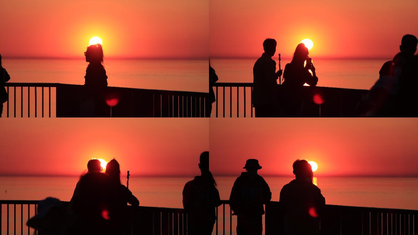 在海边平台上看夕阳的人