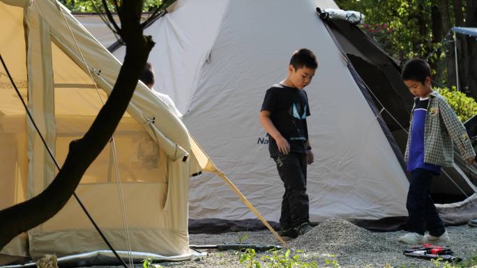 小孩在帐篷边玩耍露营